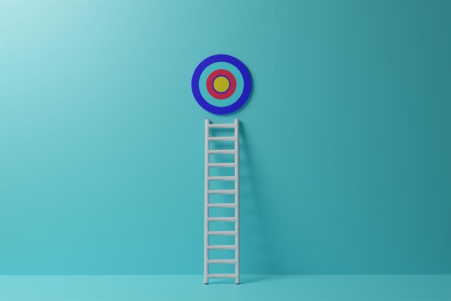 Dart board with ladder against blue wall