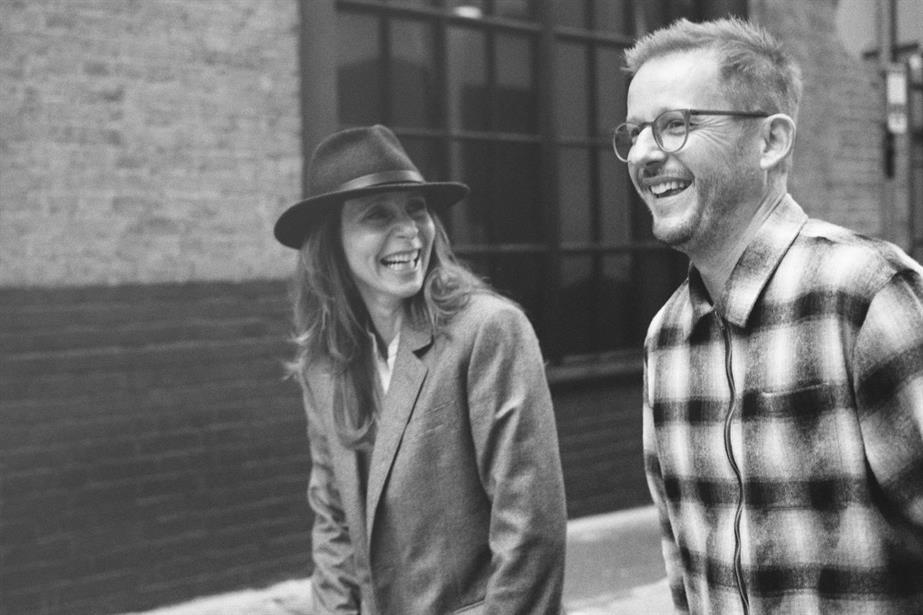 A black and white photo of Charlie Gatsky Sinclair and James Guy together, both laughing