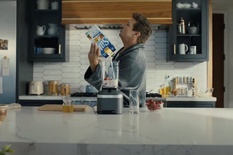 Man pouring Silk plant-based milk into blender