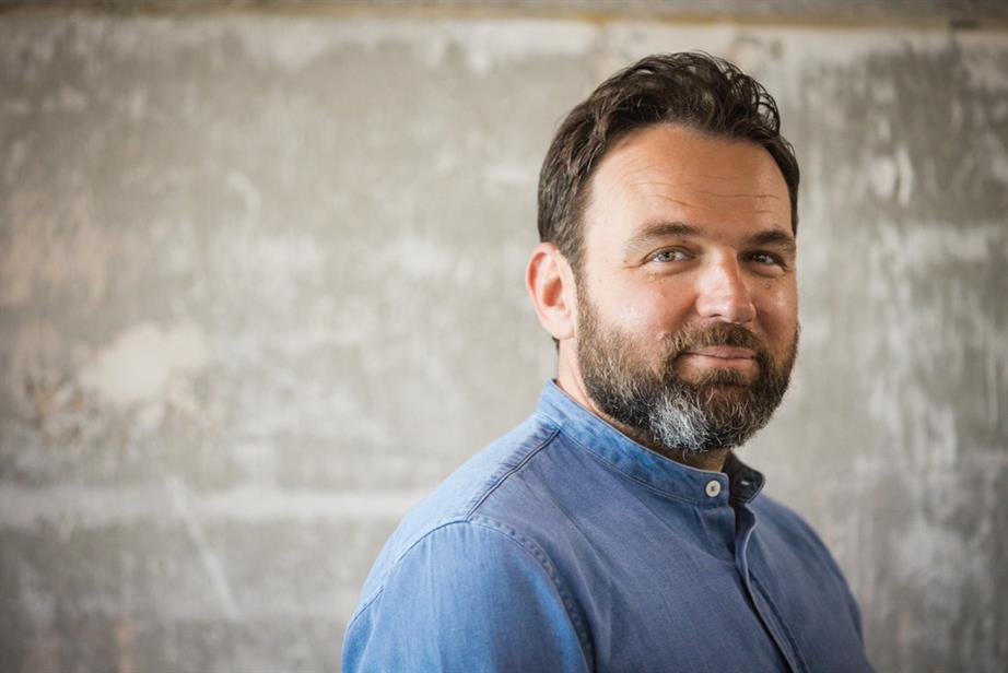 A colour portrait of Daniel Fisher, smiling vaguely into the camera