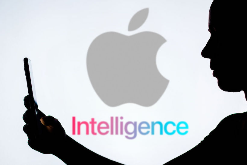 Person holding smart phone in front of Apple Intelligence logo