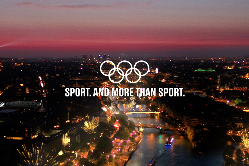 Aerial view of Paris with International Olympic Committee rings logo and text reading "Sport. And more than sport."