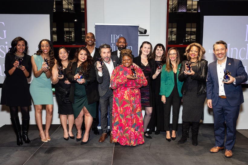 Diverse group of people standing in front of IPG Inclusion signage