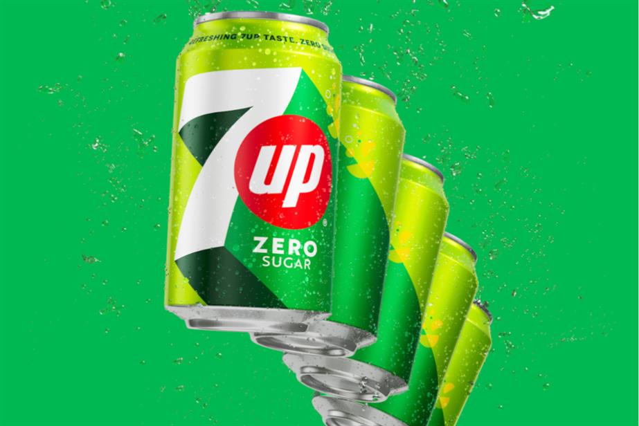 Five cans of 7UP in front of a green background 