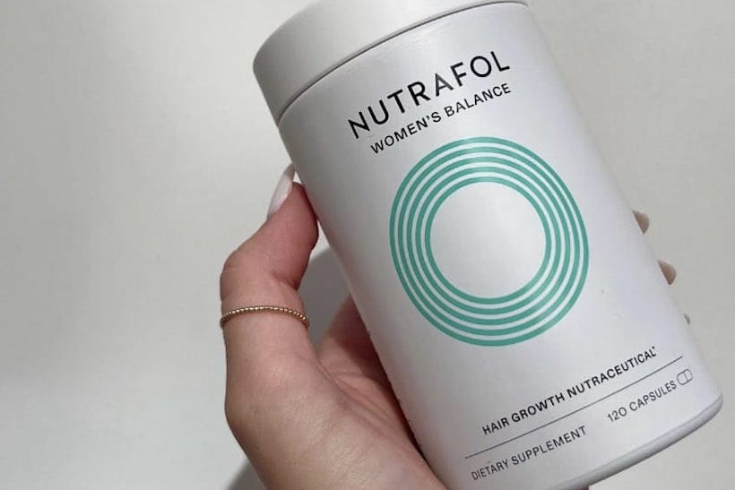 Hand holding Nutrafol jar