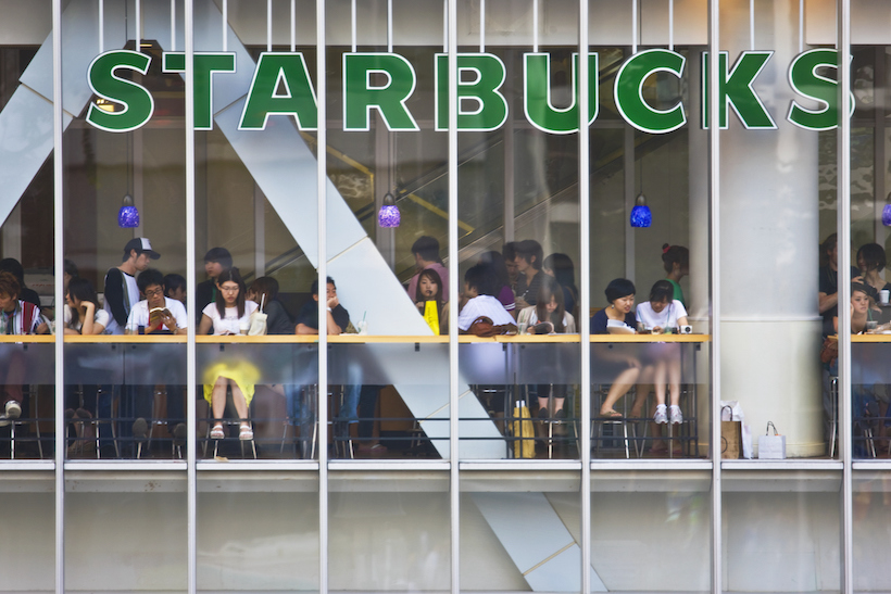 Starbucks storefront with people sitting down inside