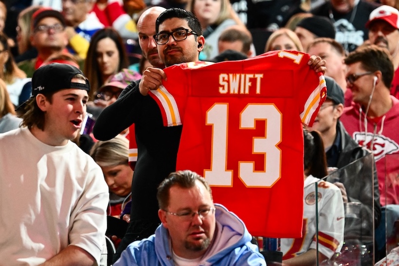 A fan holds up a customized Taylor Swift Chiefs jersey at Super Bowl Opening Night in Las Vegas.