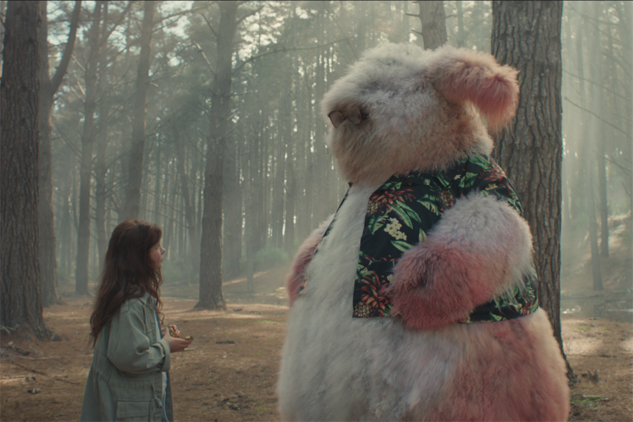 A still from the ad showing a little girl looking at a pink fluffy monster