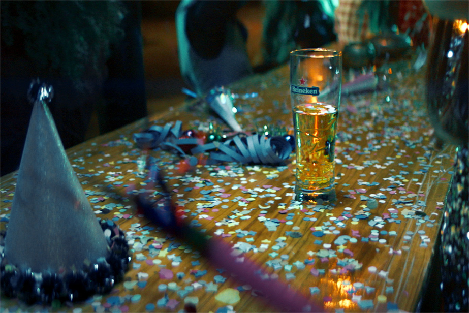 An half empy glass of Heineken is left on a table at a party 