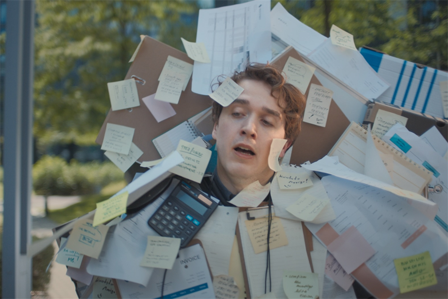 a man covered in post it notes and office stationery 